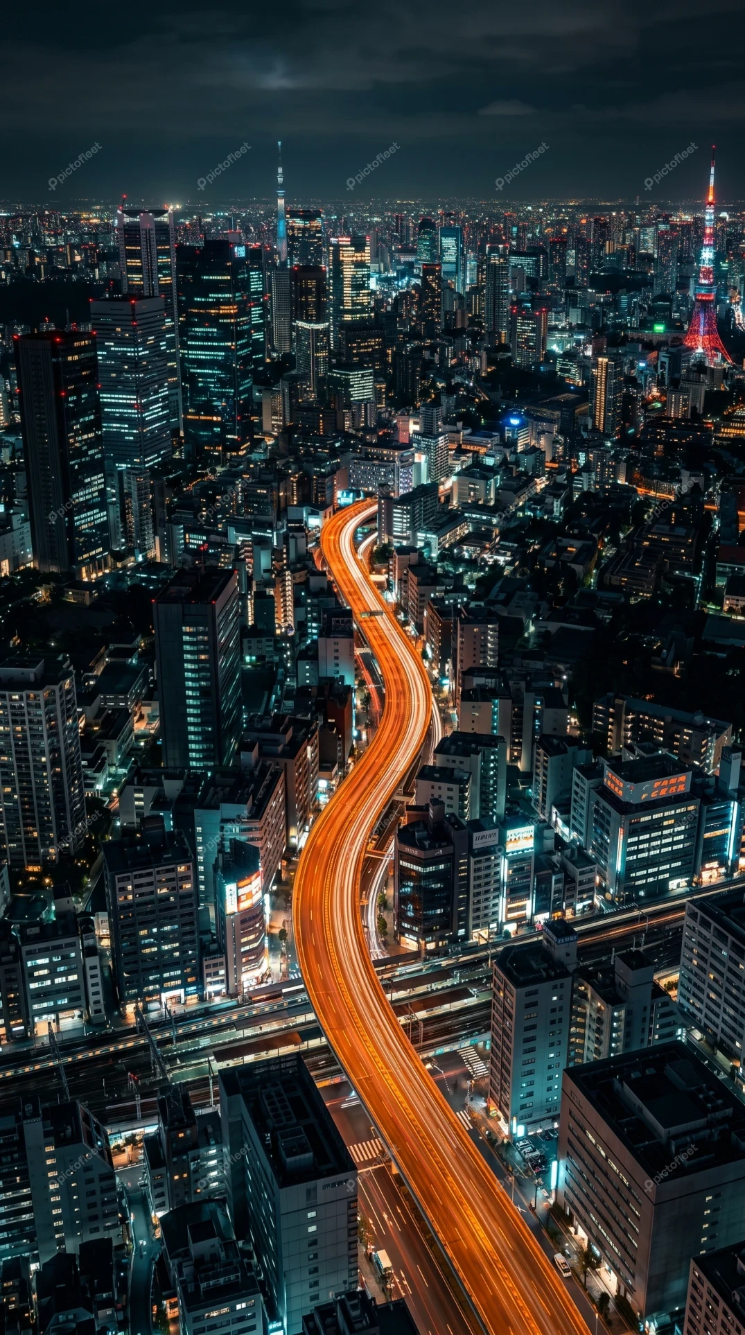 Tokyo city skyline at night with winding highway light trails