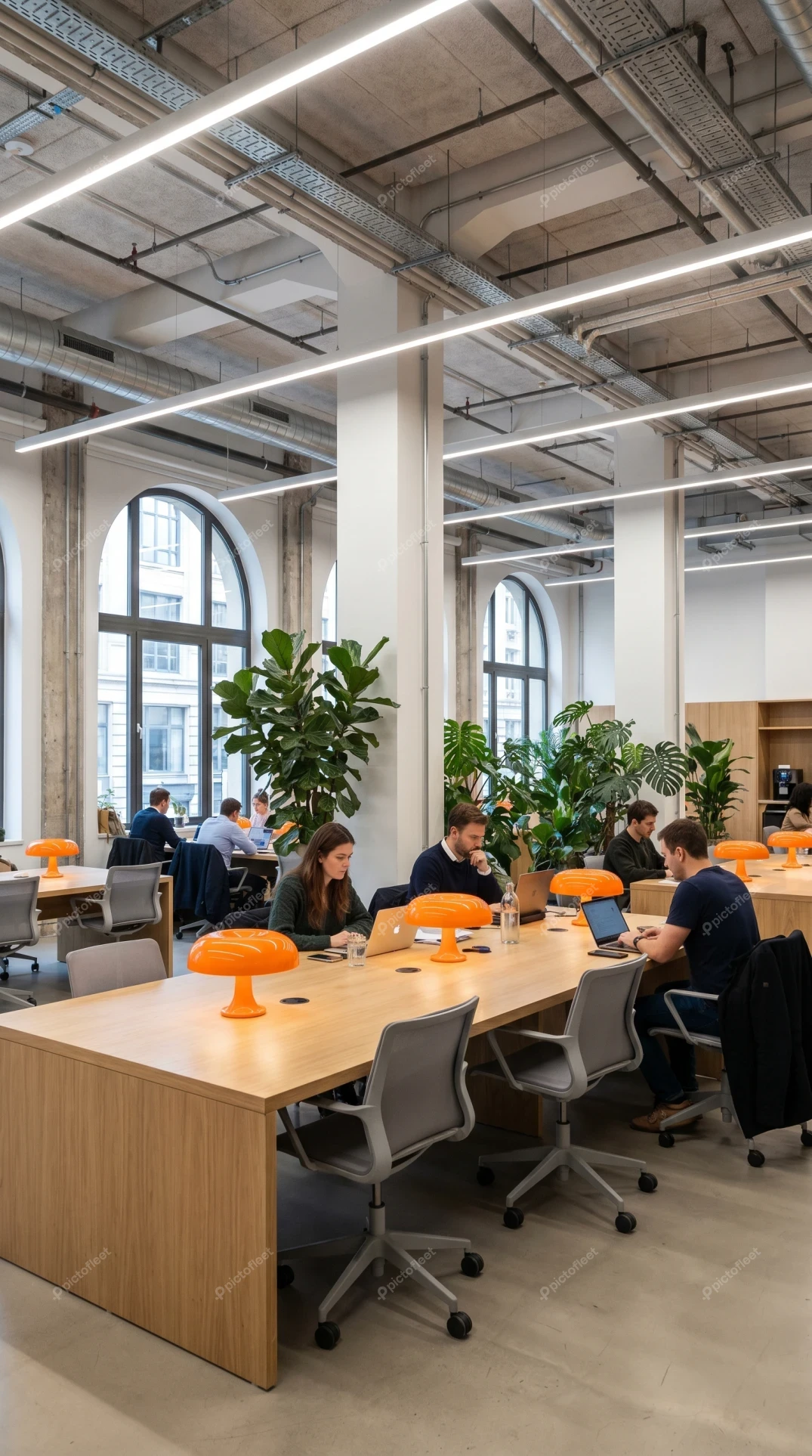 Modern industrial coworking space with people working on laptops