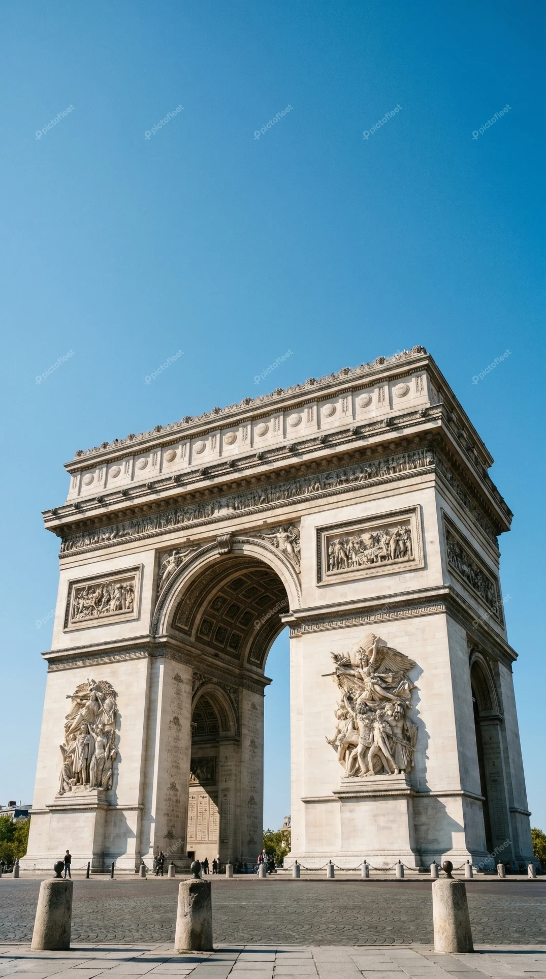 Arc de Triomphe monument under clear blue sky in Paris