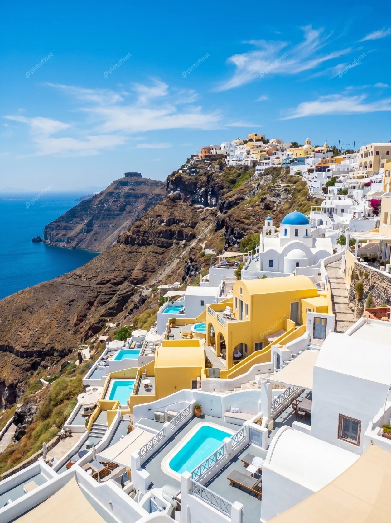Traditional white and yellow buildings overlooking the sea in Santorini